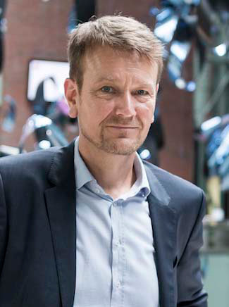 Jörg Wallner leaning against a railing – Director Innovation & Change at 2b AHEAD ThinkTank